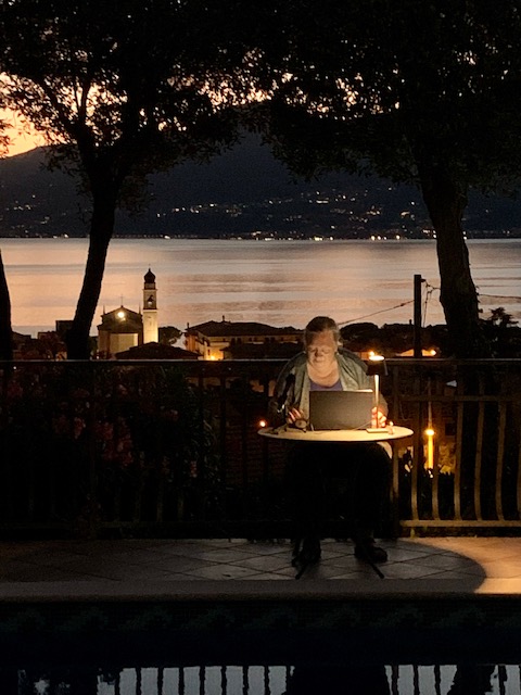 Eva-Maria Kautz schreibt am Abend vor einer Seelandschaft